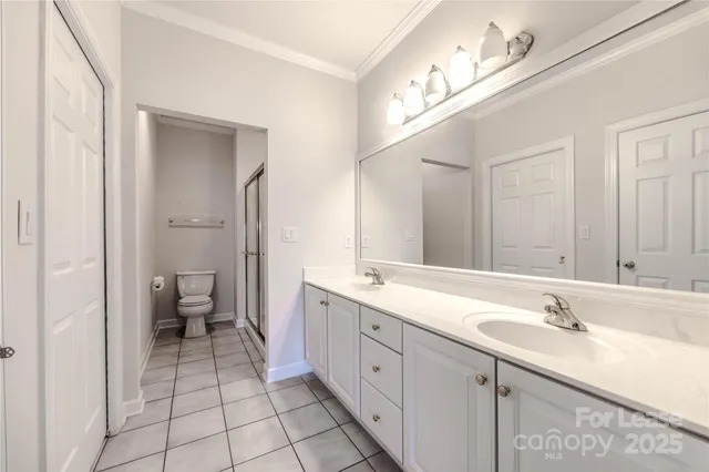 a spacious bathroom with a double vanity sink mirror and toilet
