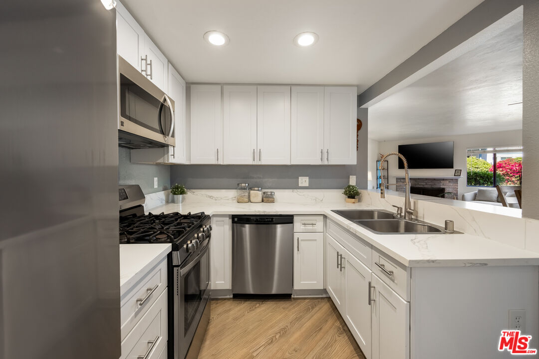 2963 Alwood Court Spring Valley, CA 91978 - Photo 6 of 20 a kitchen with stainless steel appliances a sink stove top oven and cabinets