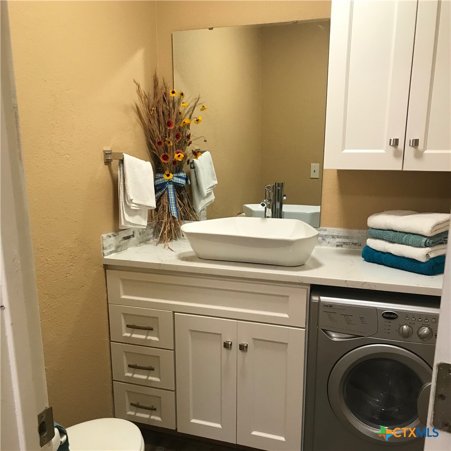 4841 Highway 35, Unit 203 Rockport, TX 78382 - Photo 14 of 23 a bathroom with a toilet a sink and mirror