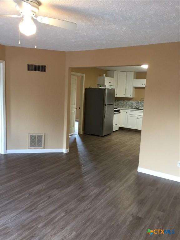 4841 Highway 35, Unit 203 Rockport, TX 78382 - Photo 16 of 23 a kitchen with stainless steel appliances a refrigerator and wooden floor