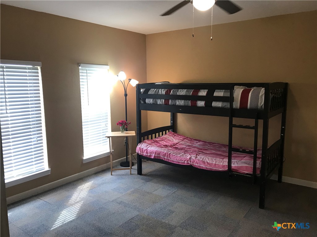 4841 Highway 35, Unit 203 Rockport, TX 78382 - Photo 8 of 23 a bedroom with a bed and a chandelier