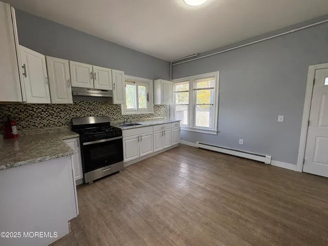 a view of an empty room with window and a ceiling fan