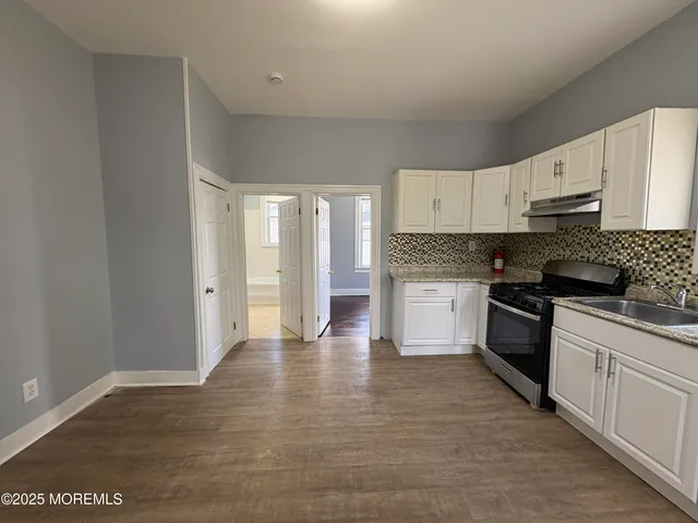 a view of a livingroom with wooden floor and windows