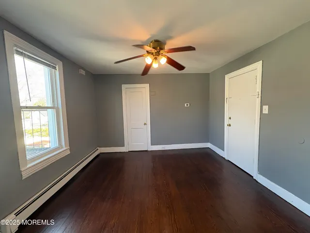 a view of a ceiling fan and wooden floor in an empty room