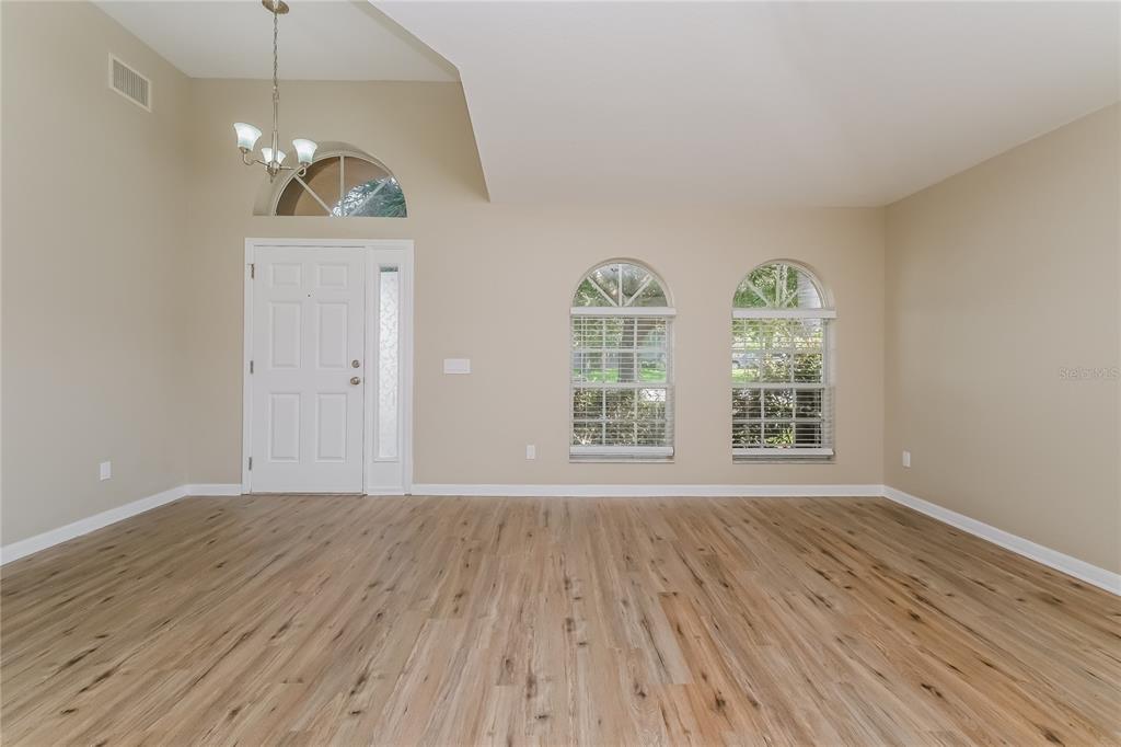 17326 Poppy Fields Lane Land O Lakes, FL 34638 - Photo 2 of 15 an empty room with wooden floor fan and windows