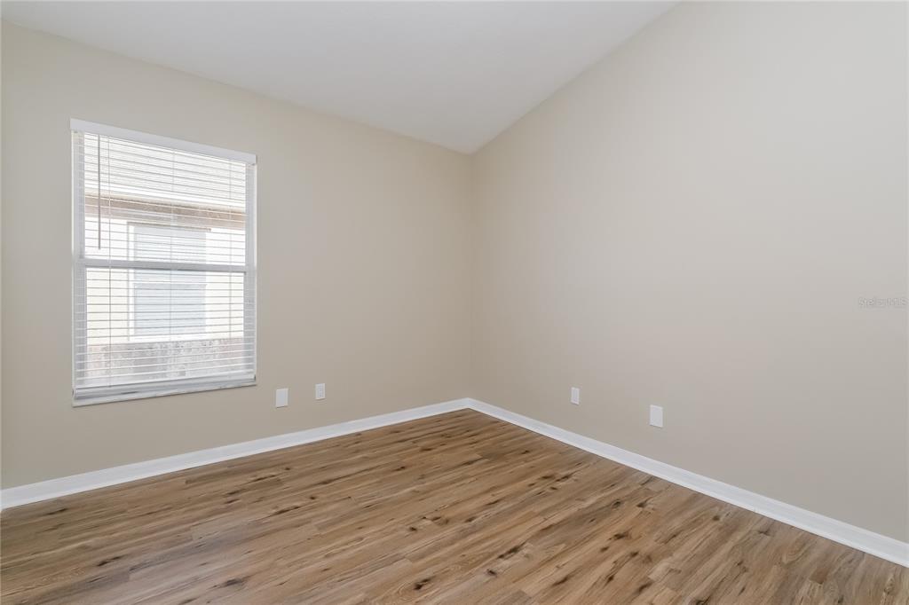 17326 Poppy Fields Lane Land O Lakes, FL 34638 - Photo 10 of 15 wooden floor in an empty room with a window