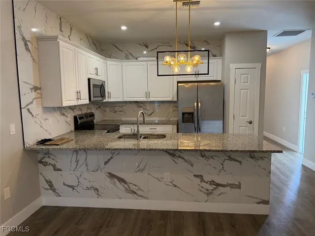 a kitchen with stainless steel appliances granite countertop a sink a stove and a microwave