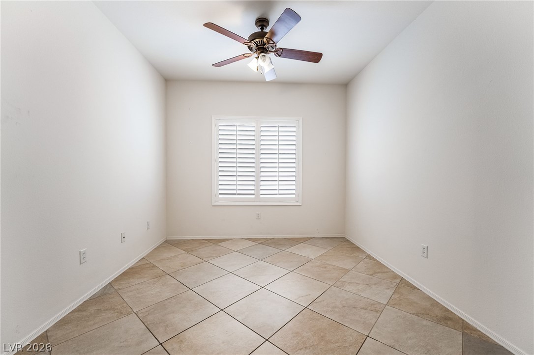 3033 Hartsville Road Henderson, NV 89052 - Photo 23 of 41 A versatile space features a window with plantation shutters and durable tile flooring, creating an inviting atmosphere.
