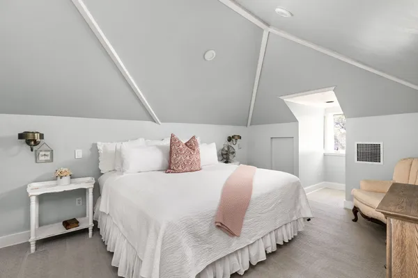 a bedroom with a bed and a lamp on the dresser