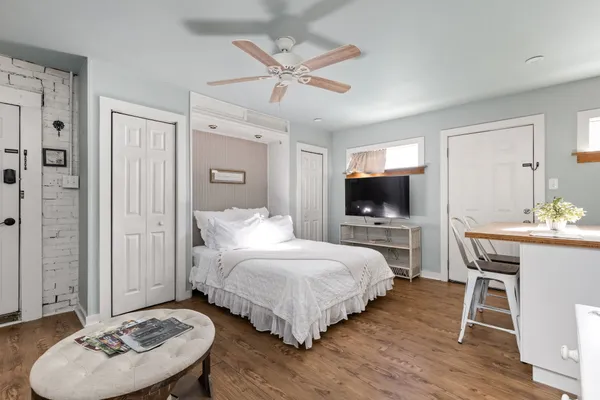 a bedroom with a bed a flat screen tv and a couch