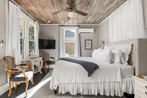a bedroom with a bed a flat screen tv and a large window with the outer view