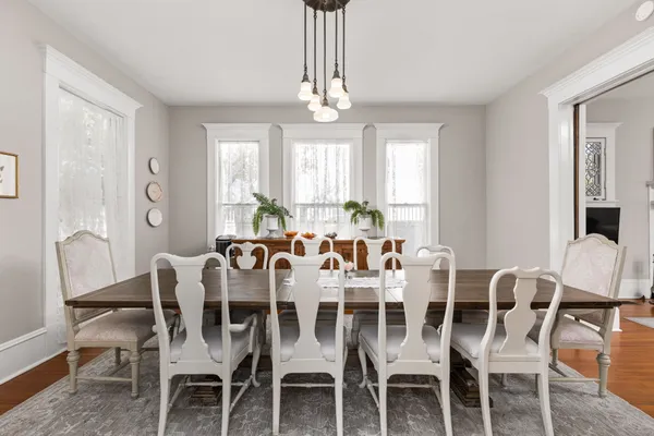 a view of a dining room with furniture a chandelier and wooden floor