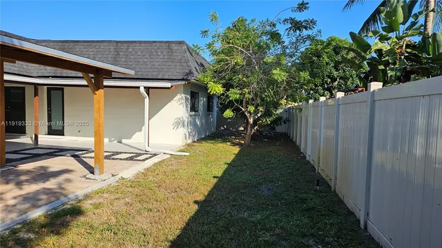 a view of a house with a yard and potted plants