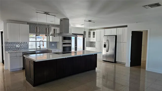 a kitchen with stainless steel appliances granite countertop a refrigerator and a stove