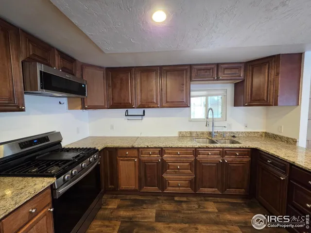 a kitchen with a sink stove top oven and cabinets