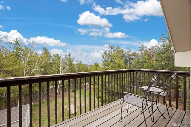 a view of a balcony with wooden floor & fence