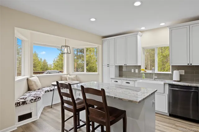a kitchen with a table chairs sink and cabinets