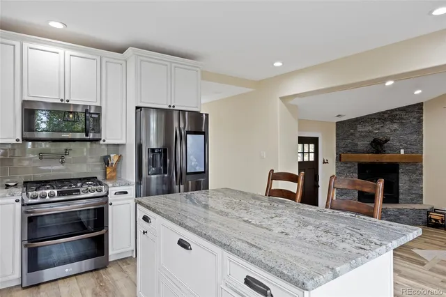 a kitchen with granite countertop a stove and refrigerator