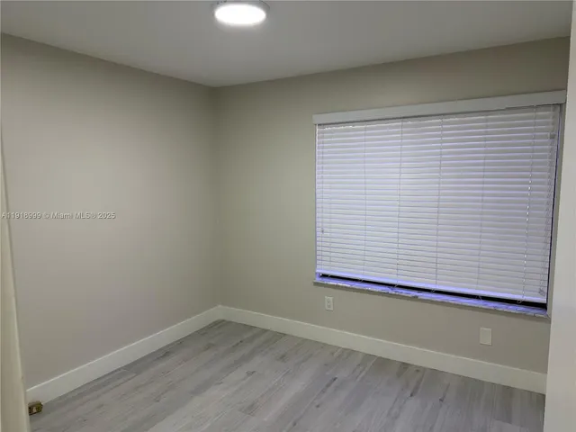 a view of a small space with wooden floor and a window
