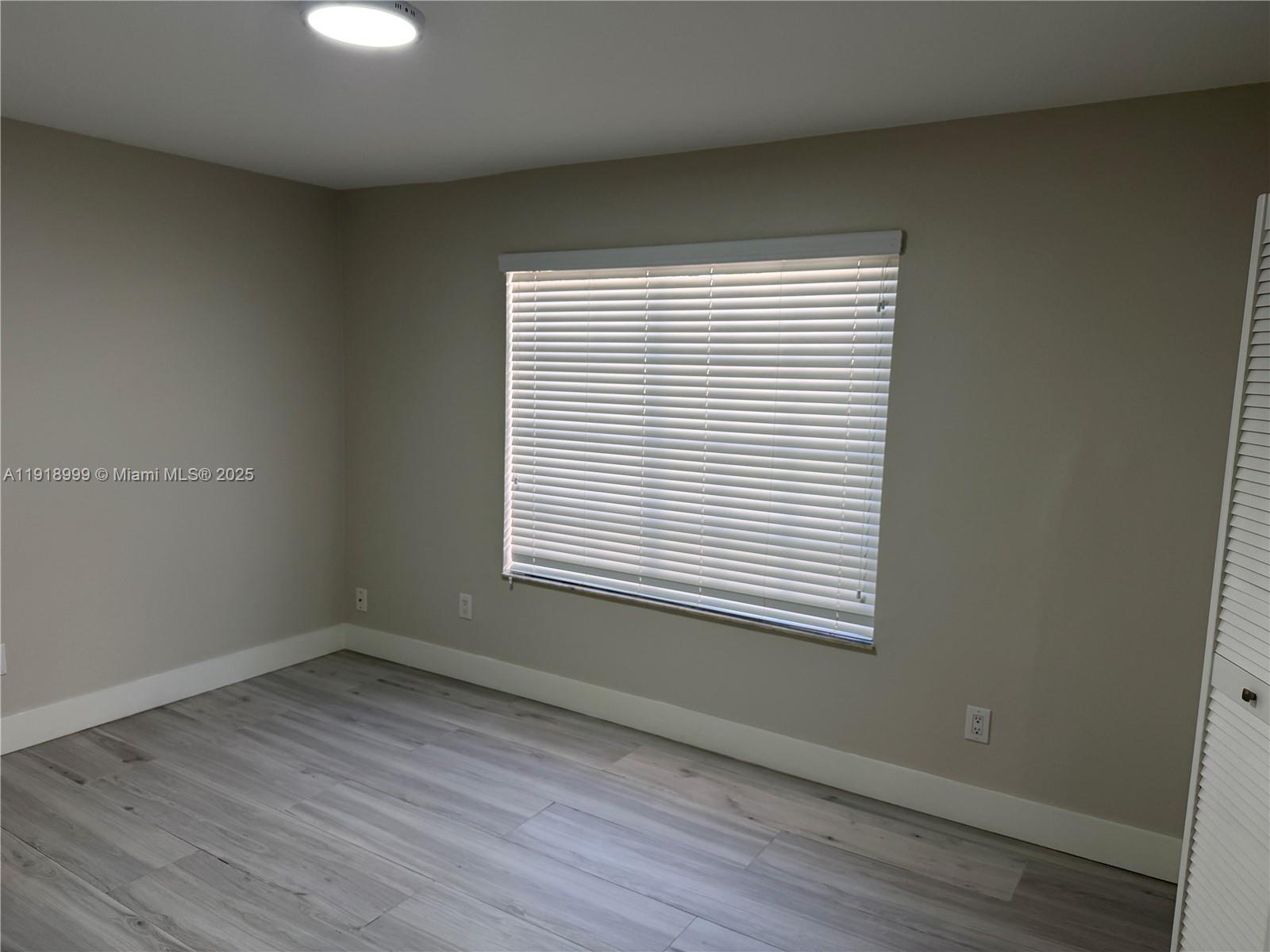 10241 Southwest 132nd Avenue Miami, FL 33186 - Photo 14 of 26 an empty room with wooden floor and a window