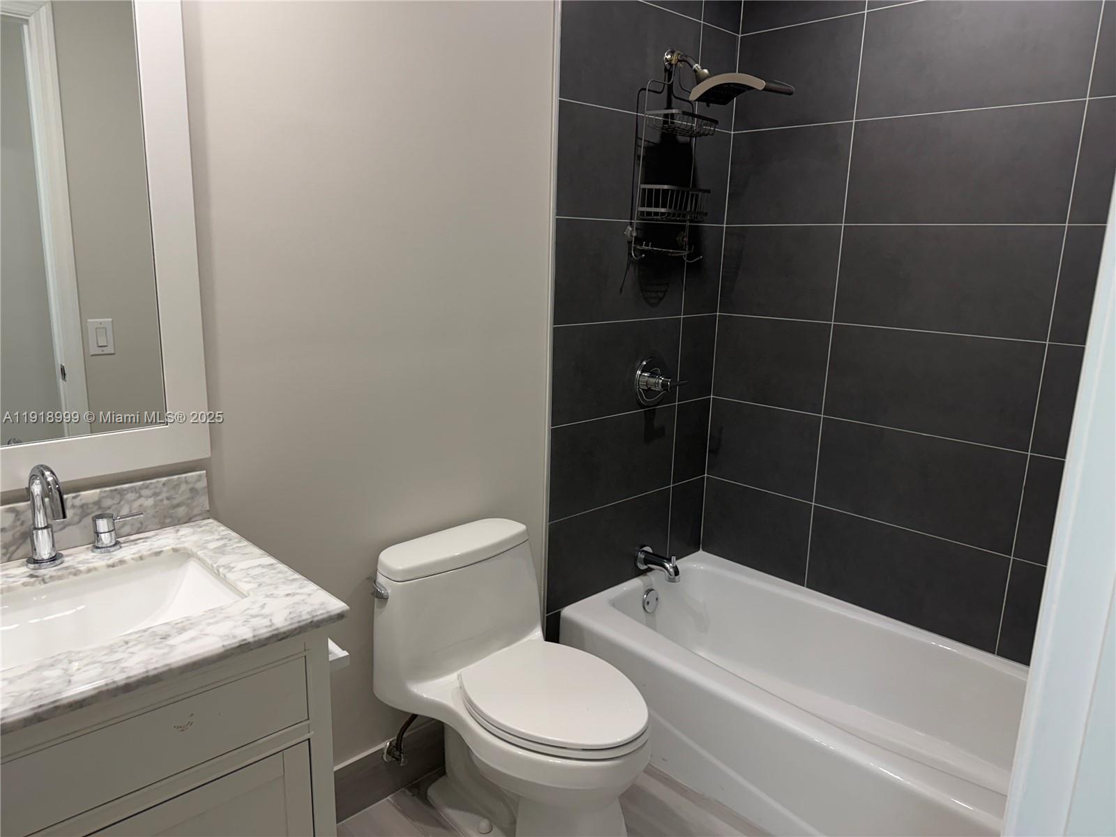 10241 Southwest 132nd Avenue Miami, FL 33186 - Photo 15 of 26 a bathroom with a granite countertop toilet a sink and bathtub
