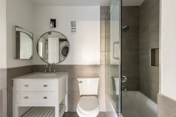 a bathroom with a toilet a sink and mirror