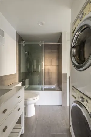 a bathroom with a bathtub sink mirror and toilet