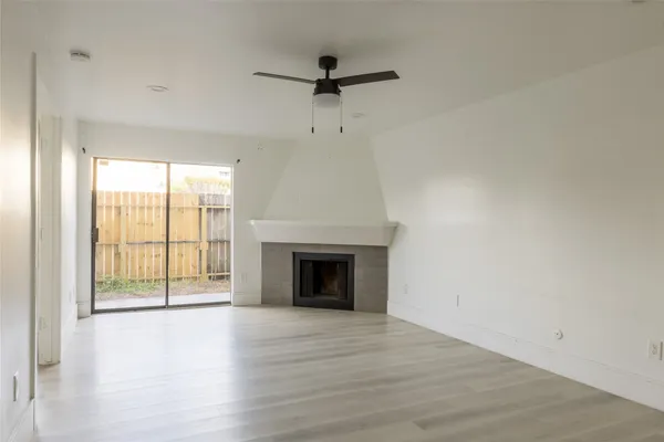 a view of an empty room with a fireplace and a window