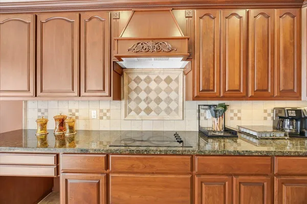 a kitchen with stainless steel appliances granite countertop a refrigerator and a stove top oven