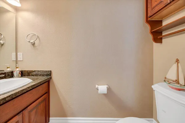 a bathroom with a granite countertop sink a mirror and a shower