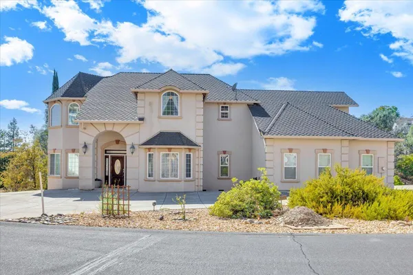 a living room with furniture a chandelier and a large window