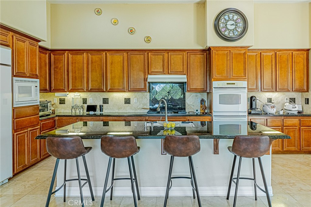 4088 Shady Ridge Circle Corona, CA 92881 - Photo 35 of 47 a kitchen with stainless steel appliances granite countertop a stove a sink and a refrigerator