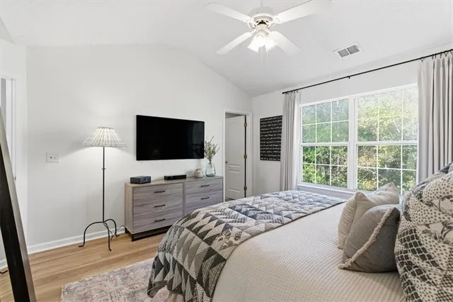a bedroom with a bed and a flat screen tv on dresser