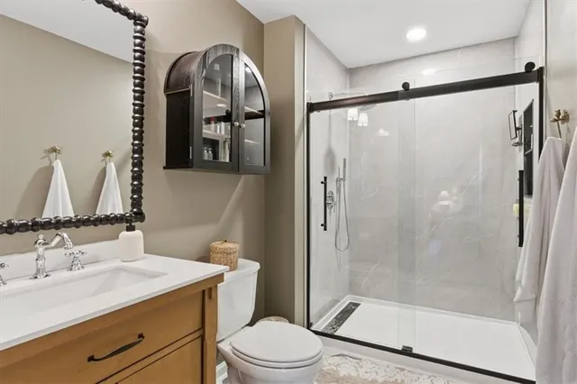 a bathroom with a granite countertop sink mirror vanity and toilet