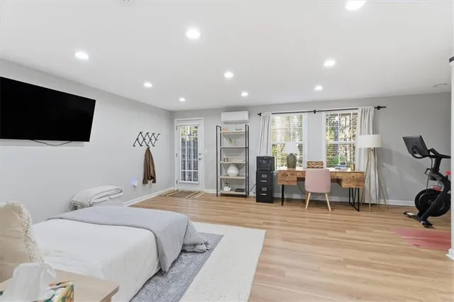 a spacious bedroom with a bed and a flat screen tv