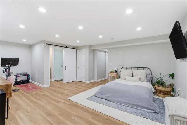 a spacious bedroom with a bed and a flat screen tv