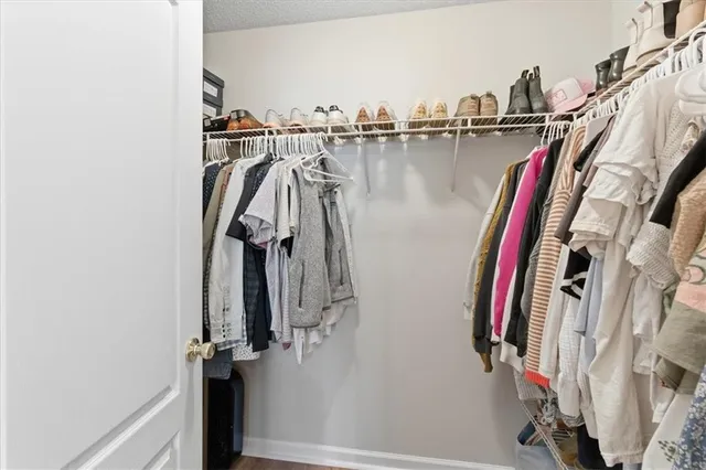 a view of walk in closet with clothes and shoes