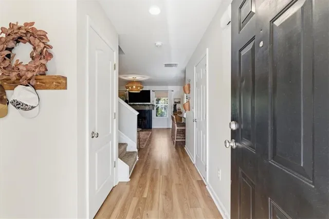 a view of a hallway with wooden floor and a living room