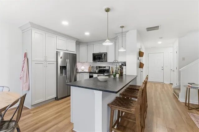 a kitchen with stainless steel appliances a refrigerator a sink a stove a microwave and wooden cabinets