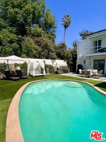 a swimming pool with outdoor seating and yard