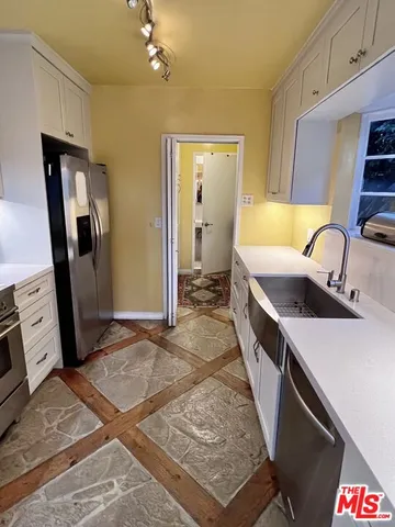a view of a kitchen with sink and refrigerator
