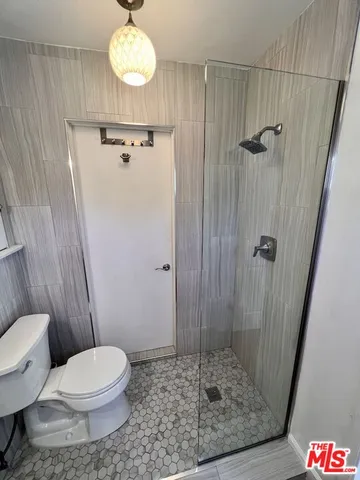 a bathroom with a toilet and a shower