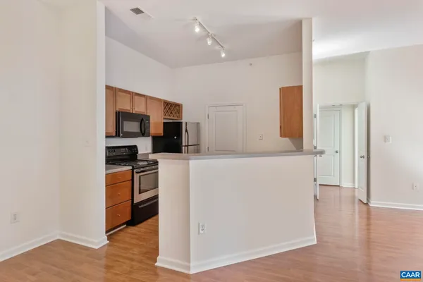 a view of kitchen with stainless steel appliances a refrigerator and a stove top oven