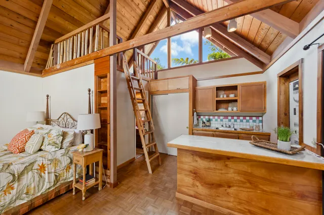 a large living room with stainless steel appliances wooden floor and furniture