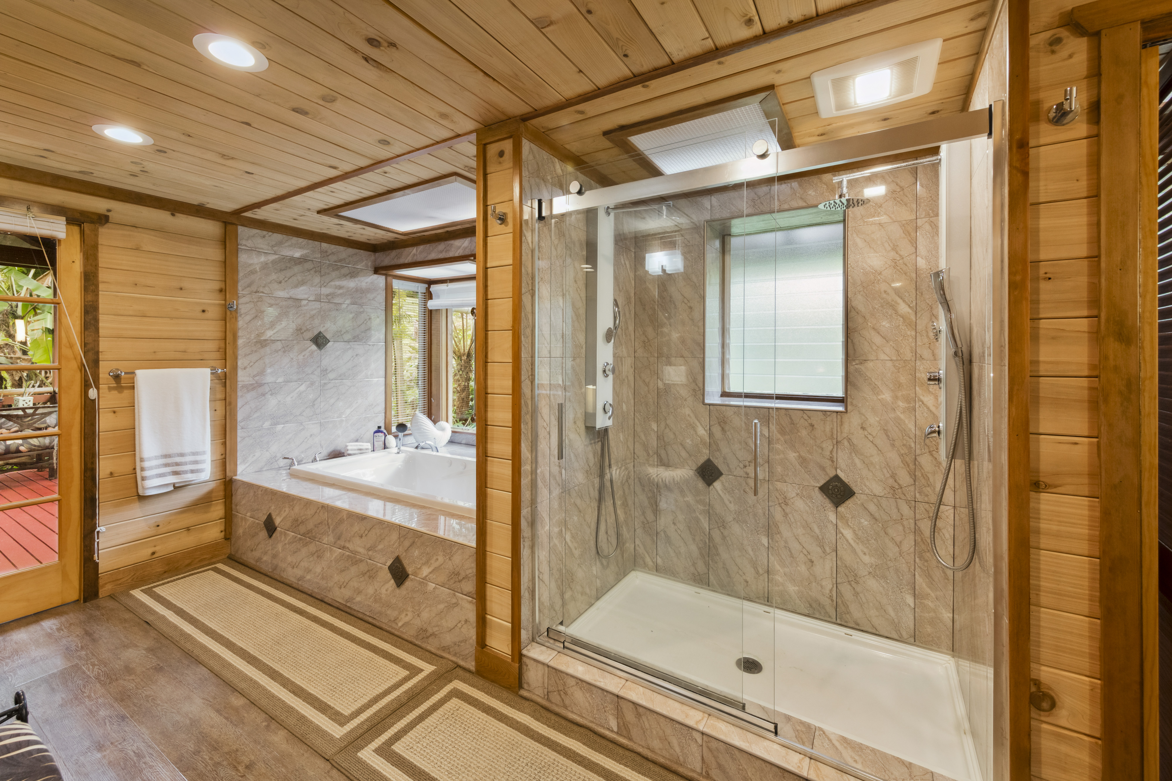 19-4245 Kekoa Nui Boulevard Volcano, HI 96785 - Photo 5 of 30 a bathroom with a glass shower door and a bathtub