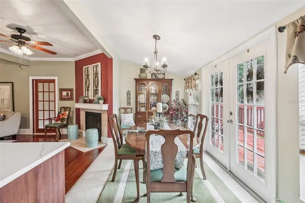 a dining room with furniture a chandelier and wooden floor