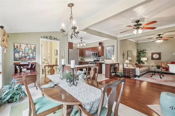 a view of a dining room and livingroom with furniture wooden floor a chandelier