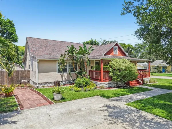 a front view of a house with a garden and plants
