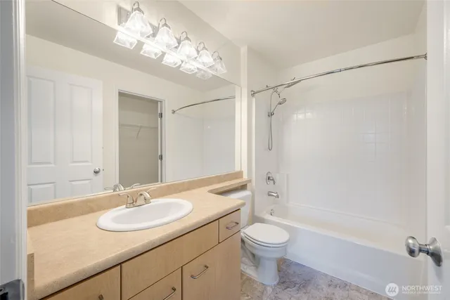 a bathroom with a granite countertop sink a toilet and shower