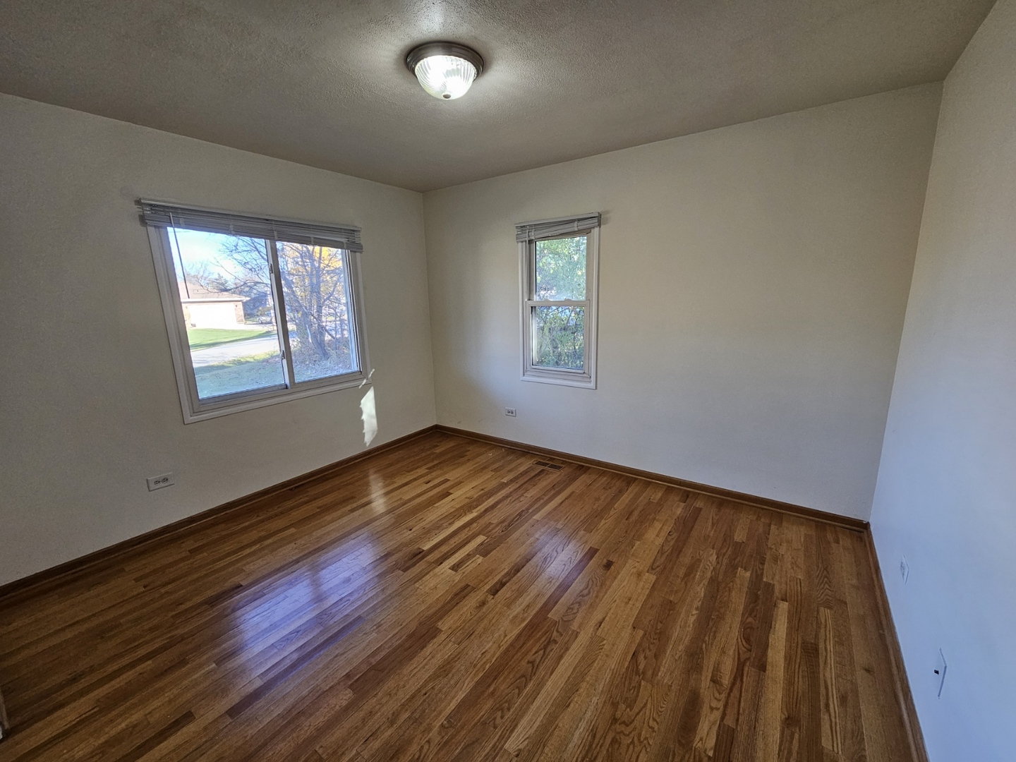 811 Hoyle Road Lombard, IL 60148 - Photo 7 of 22 a view of an empty room with wooden floor and a window